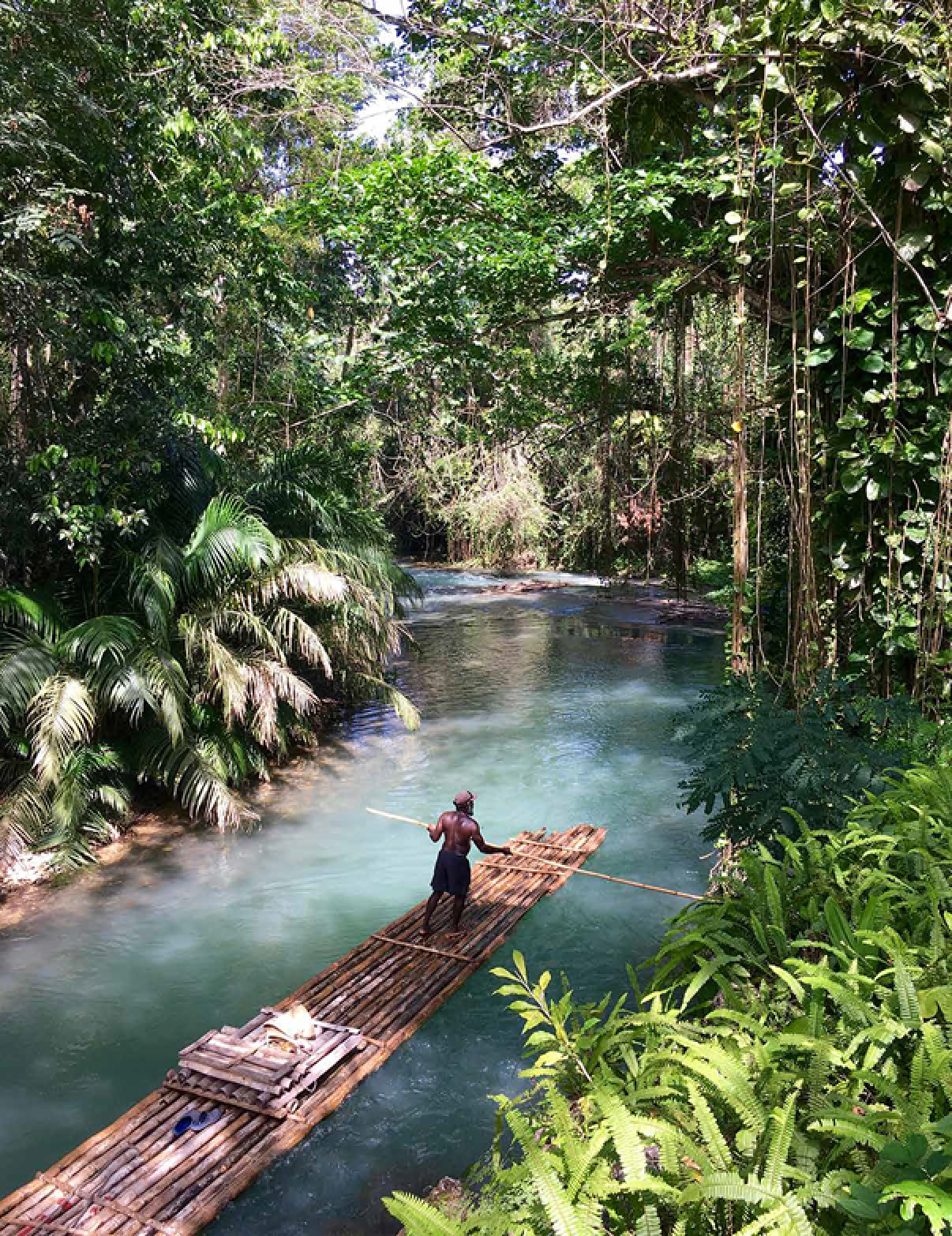 A man is standing on a wooden raft in a river, holding a paddle. AI generated content